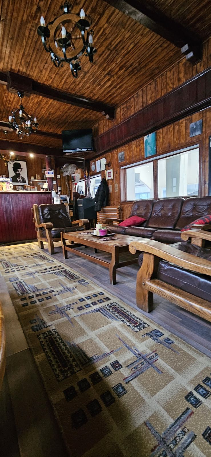 Salonul interior, cu tavan din lemn, canapele și bar